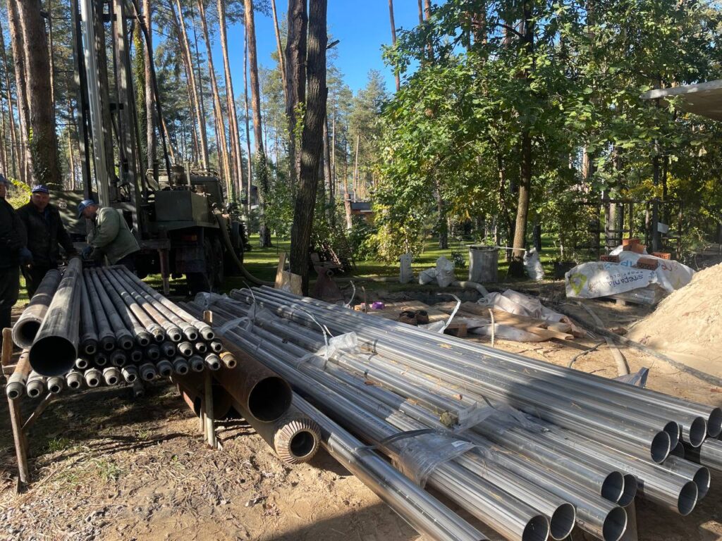 Робітники встановлюють обсадні труби після буріння